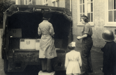 811782 Afbeelding van de voedseluitdeling ('Canadese pap') uit de achterbak van een vrachtwagen op een onbekende ...